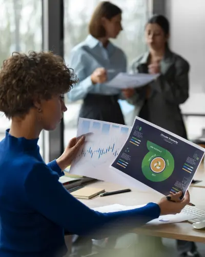 a woman analyzes a chart displayed on her computer screen, focusing intently on the data presented